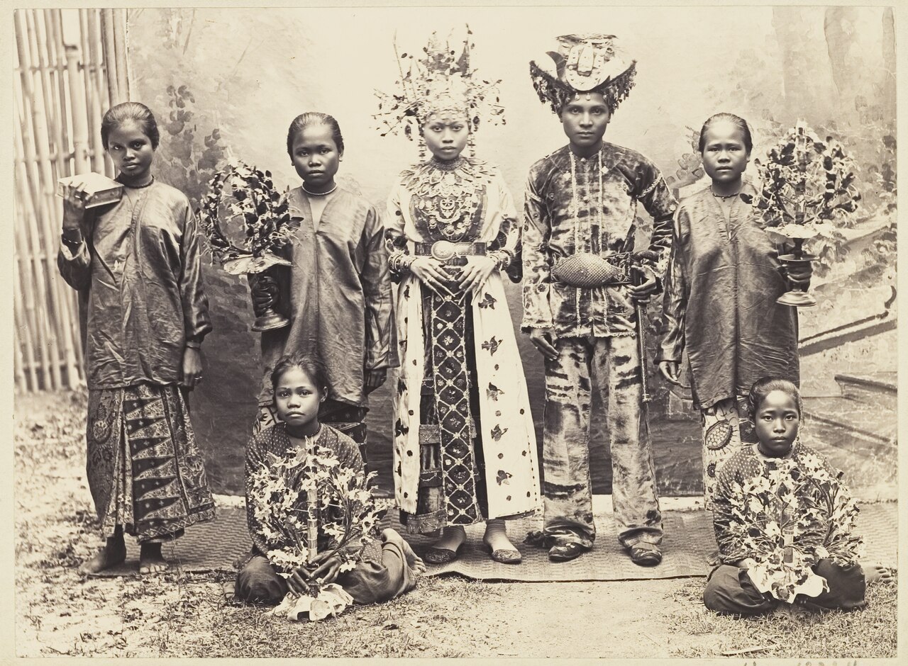 Pasangan pengantin kelas menengah di Gorontalo (KITLV 3895, sekitar 1900); laman Wikipedia mengidentifikasi busana perempuan pada foto sebagai Bili'u.